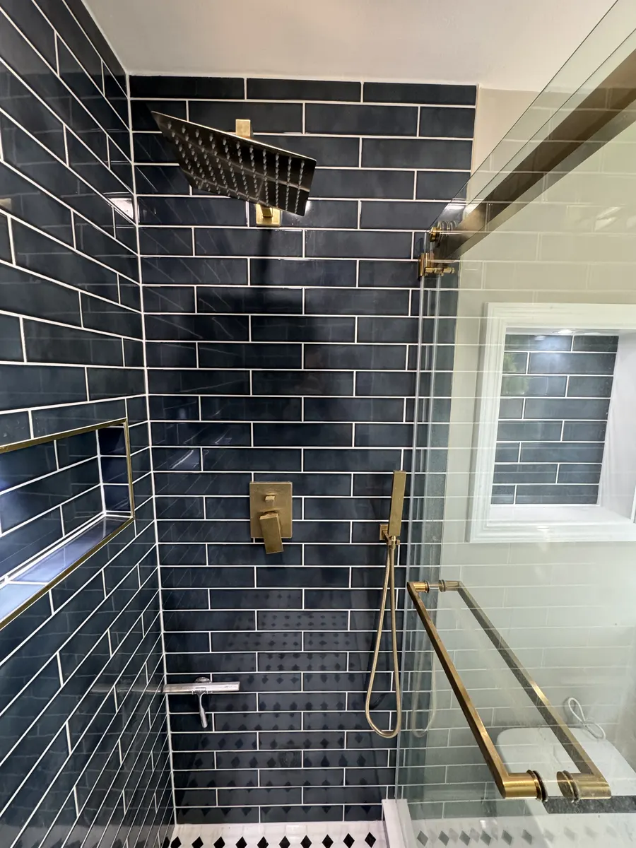 Finished shower with glass door and brass hardware